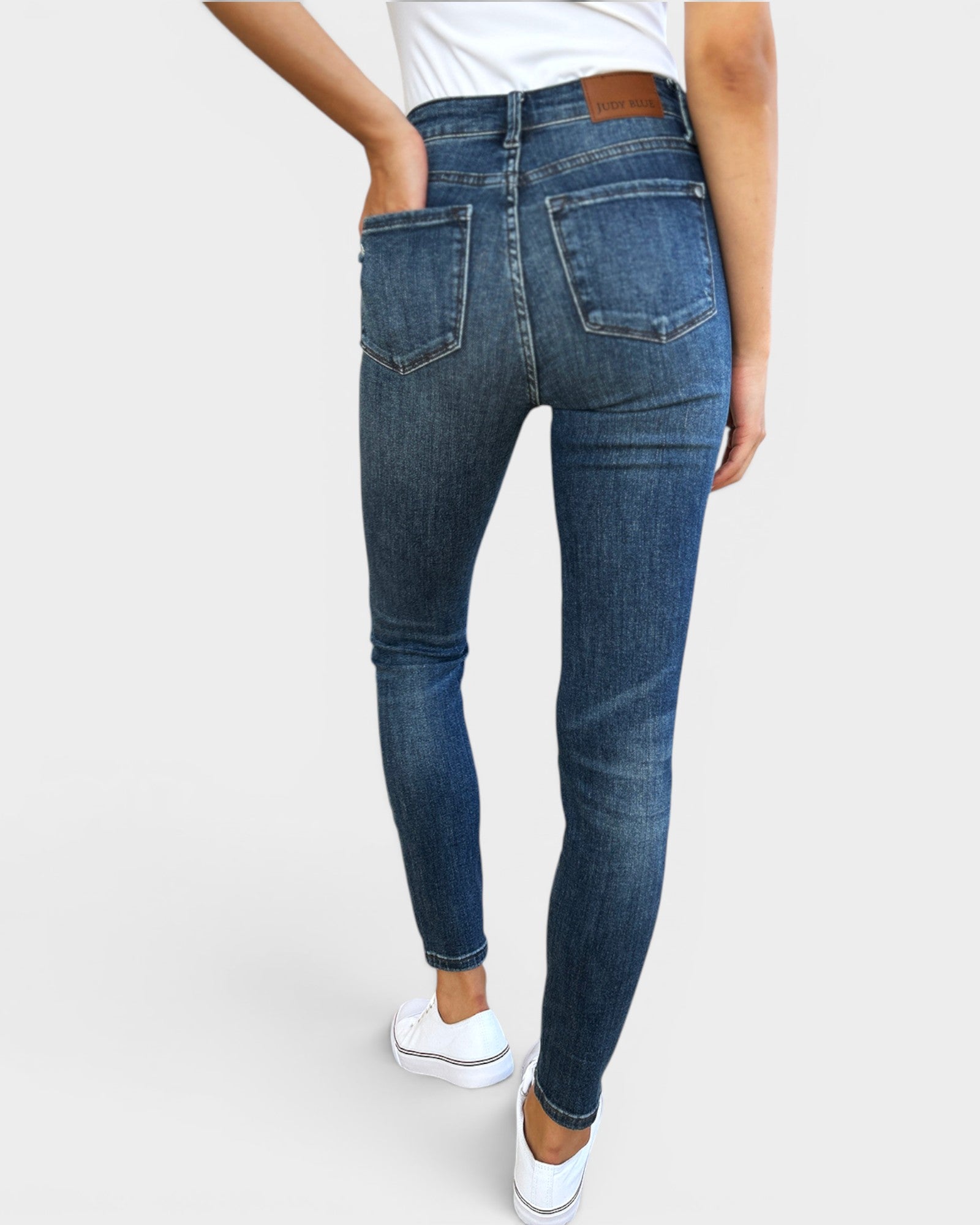 Blue jeans worn by a person on a white background
