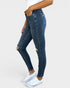 Person wearing blue jeans and white sneakers on a plain background