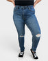 Person wearing blue jeans with slight distressing on a white background