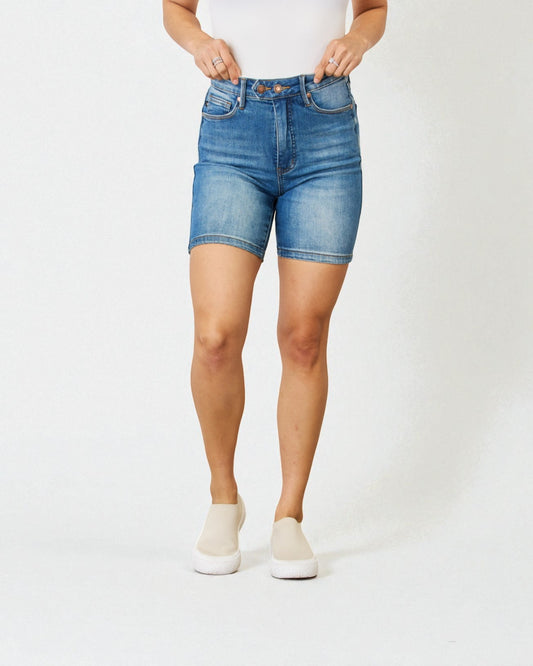 Person wearing blue denim shorts on a white background