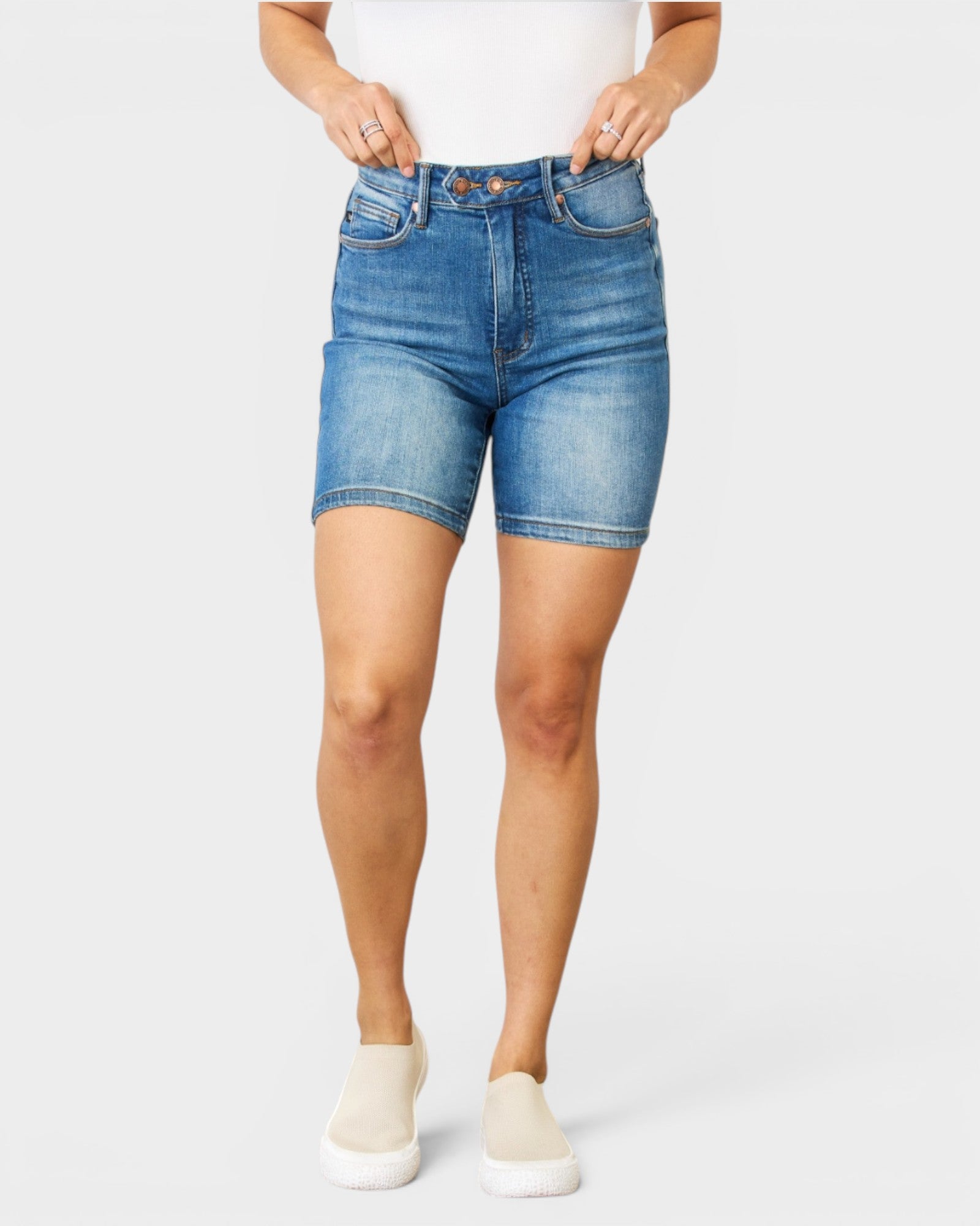 Person wearing blue denim shorts on a white background