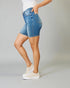 Person wearing blue denim shorts on a plain background