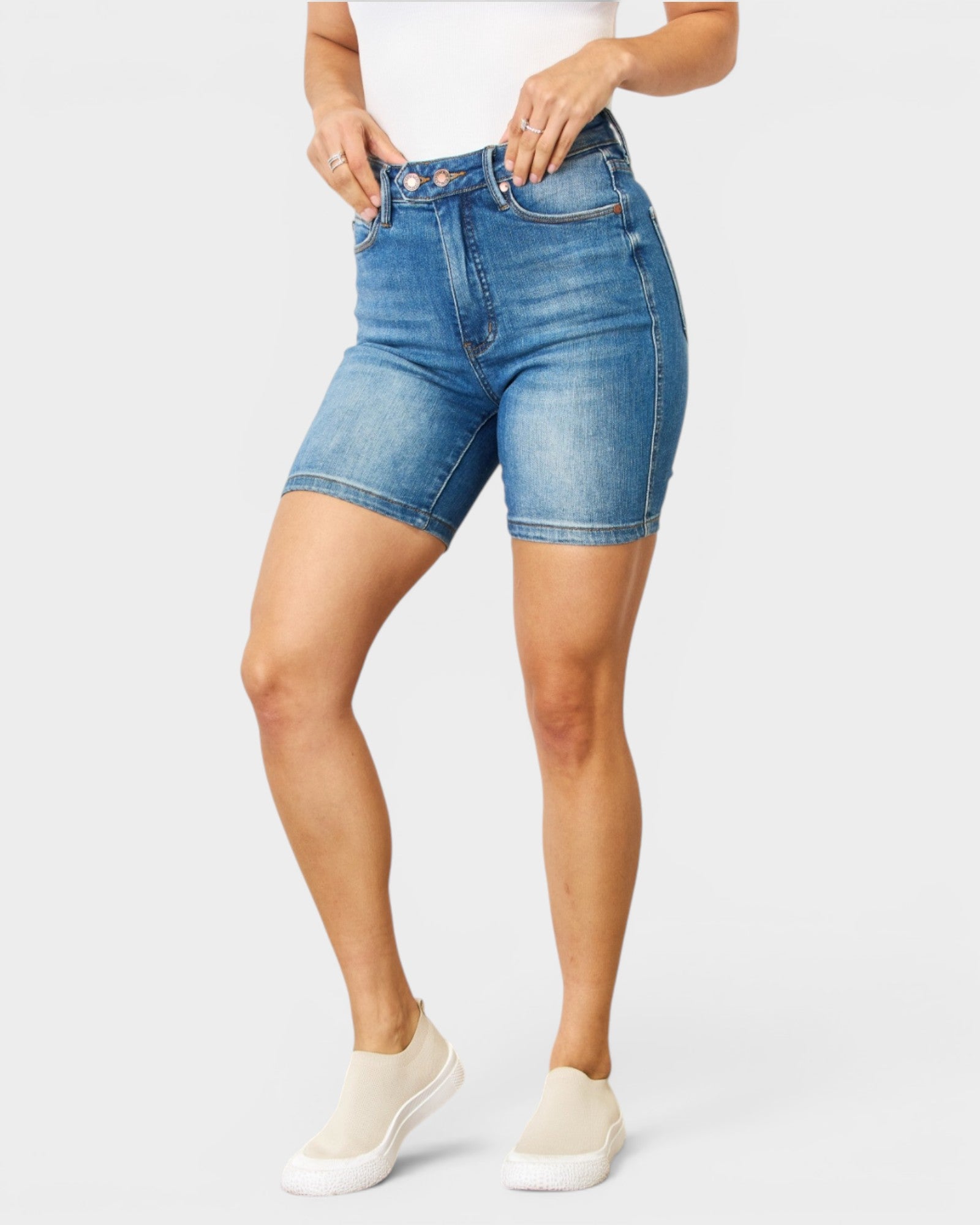Person wearing blue denim shorts on a white background