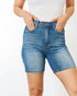 Person wearing blue denim shorts on a white background