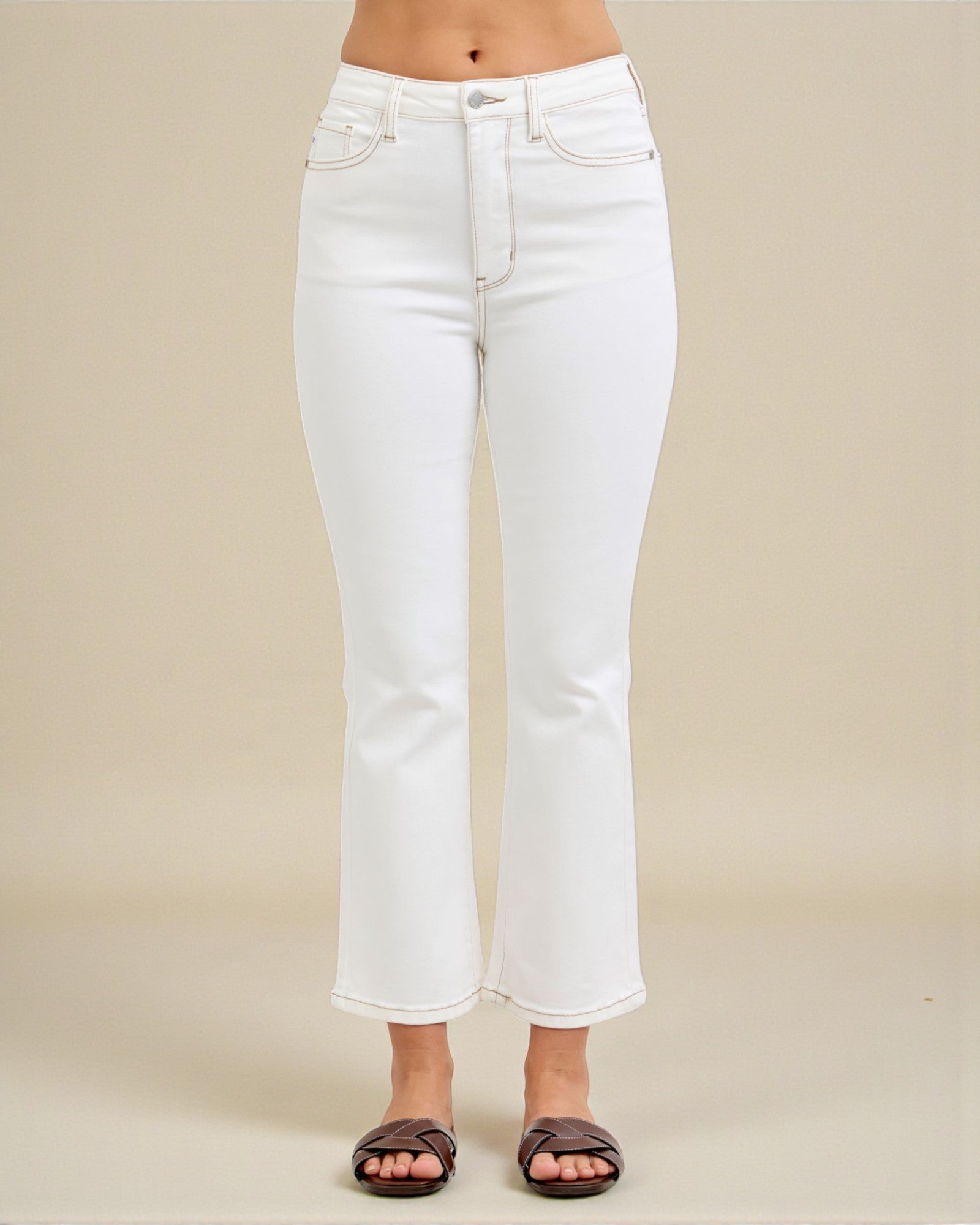 White jeans worn by a person on a beige background
