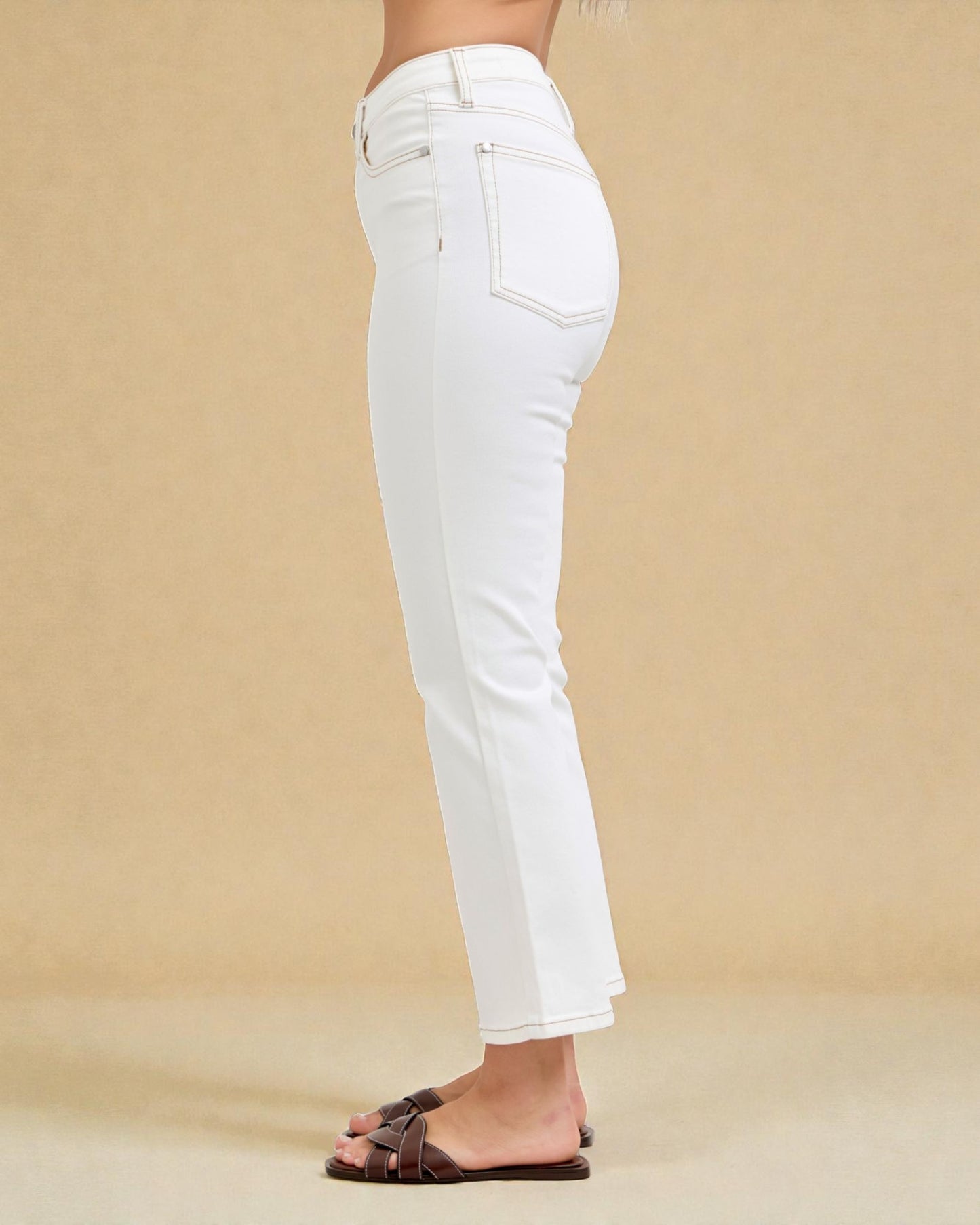 White jeans worn by a person on a beige background
