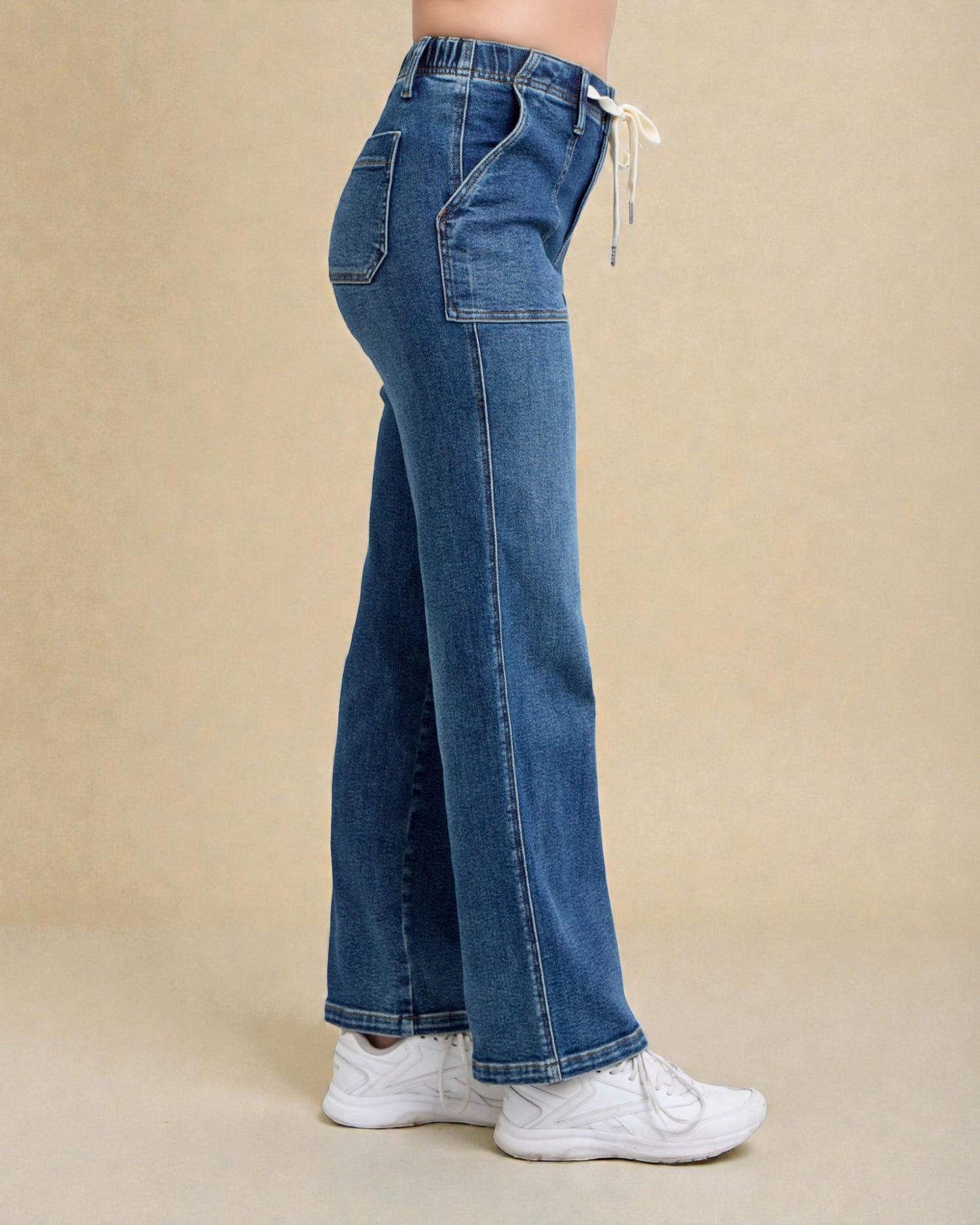 Blue jeans worn by a person on a beige background