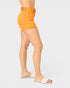 Person wearing bright orange shorts on a plain background