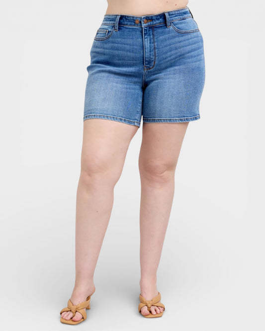 Blue denim shorts worn by a person on a white background