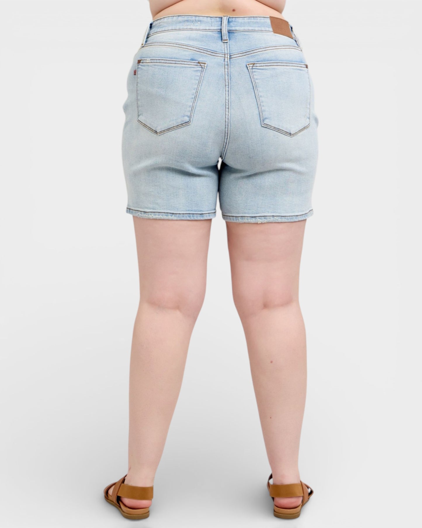 Light blue denim shorts worn by a person on a white background