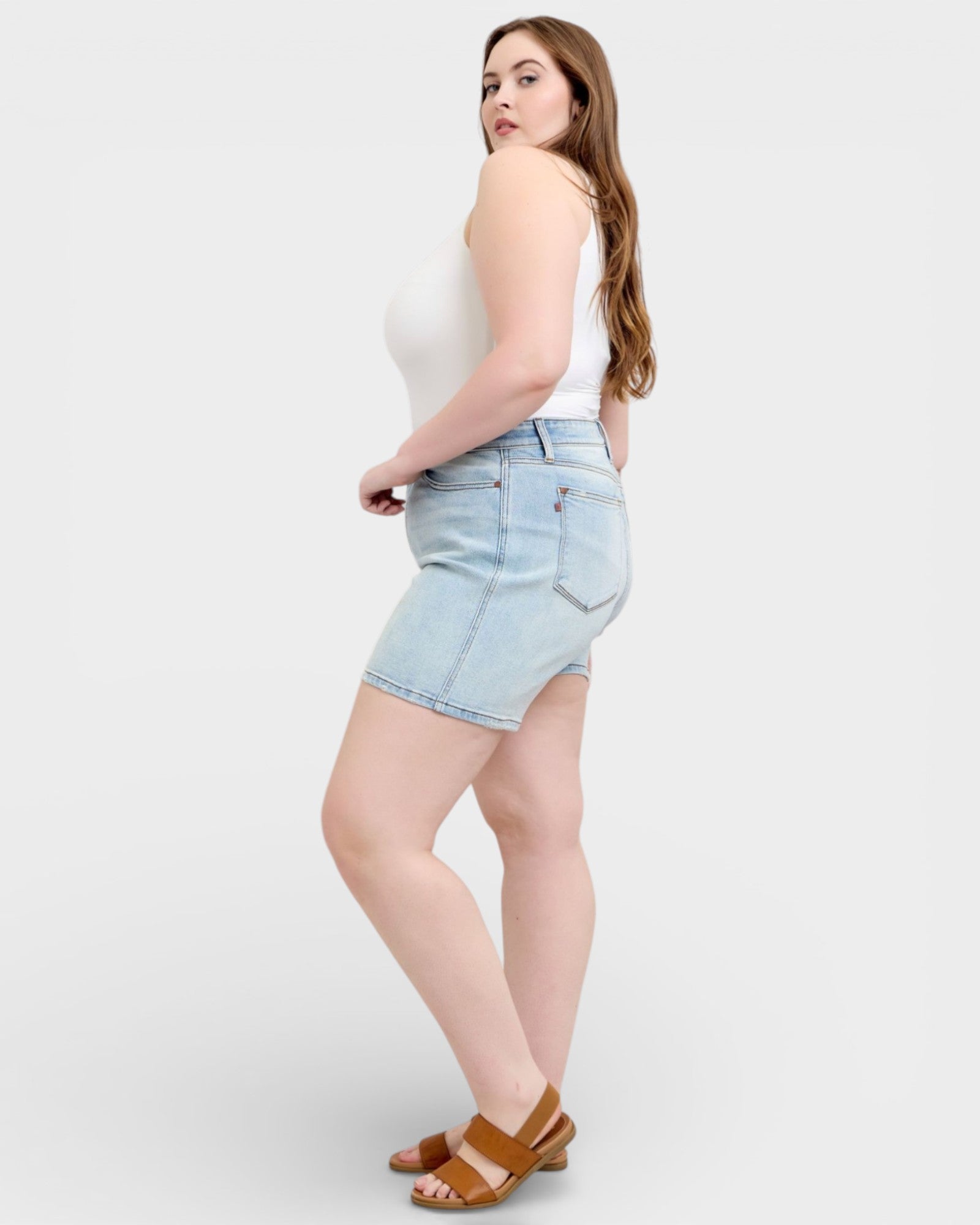Woman wearing light blue denim shorts on a white background