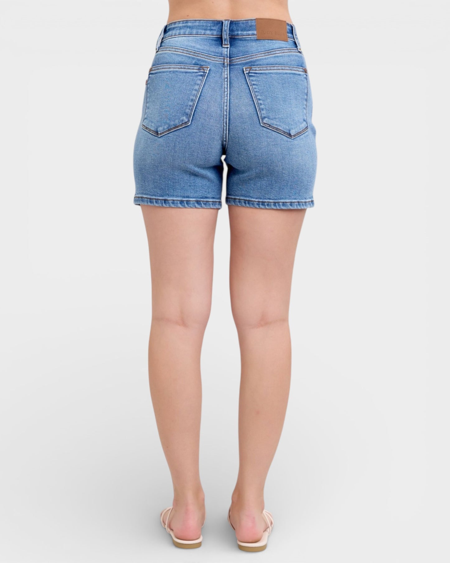 Light blue denim shorts worn by a person on a white background