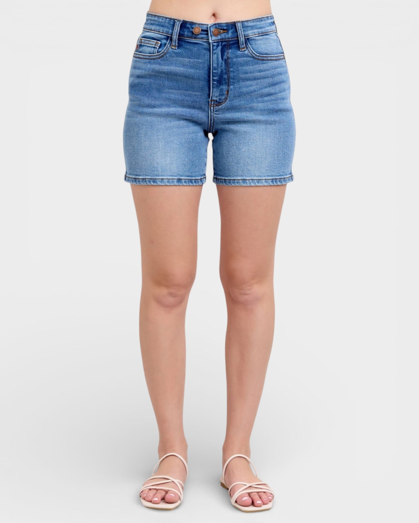 Blue denim shorts worn by a person on a white background