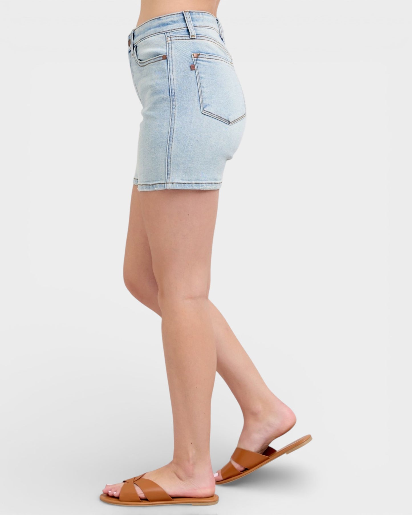 Light blue denim shorts worn by a person on a white background
