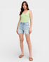 Woman wearing a light green tank top and denim shorts on a white background