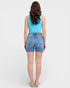Woman wearing a blue tank top and denim shorts on a white background