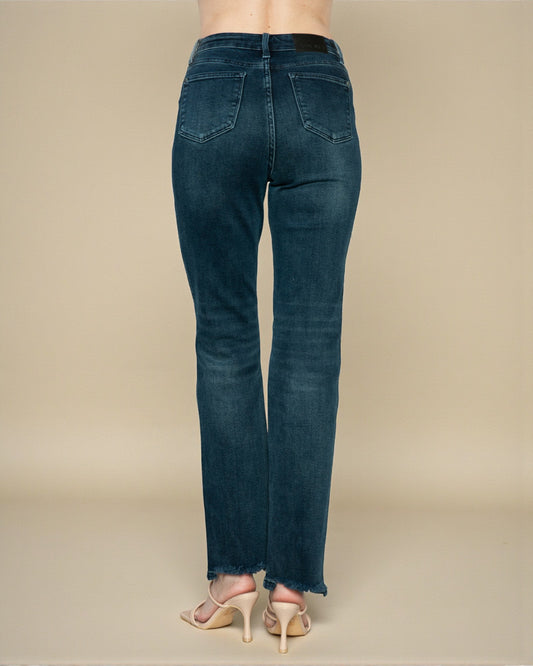 Blue jeans worn by a person on a beige background