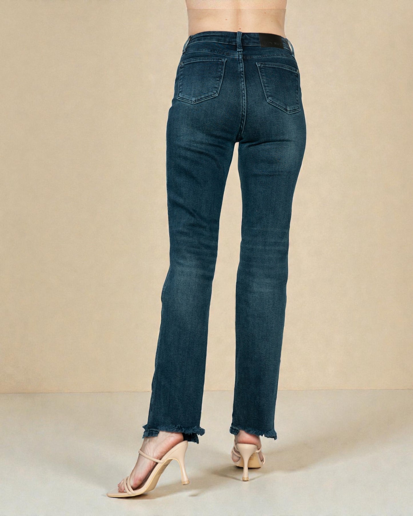 Blue jeans worn by a person on a beige background