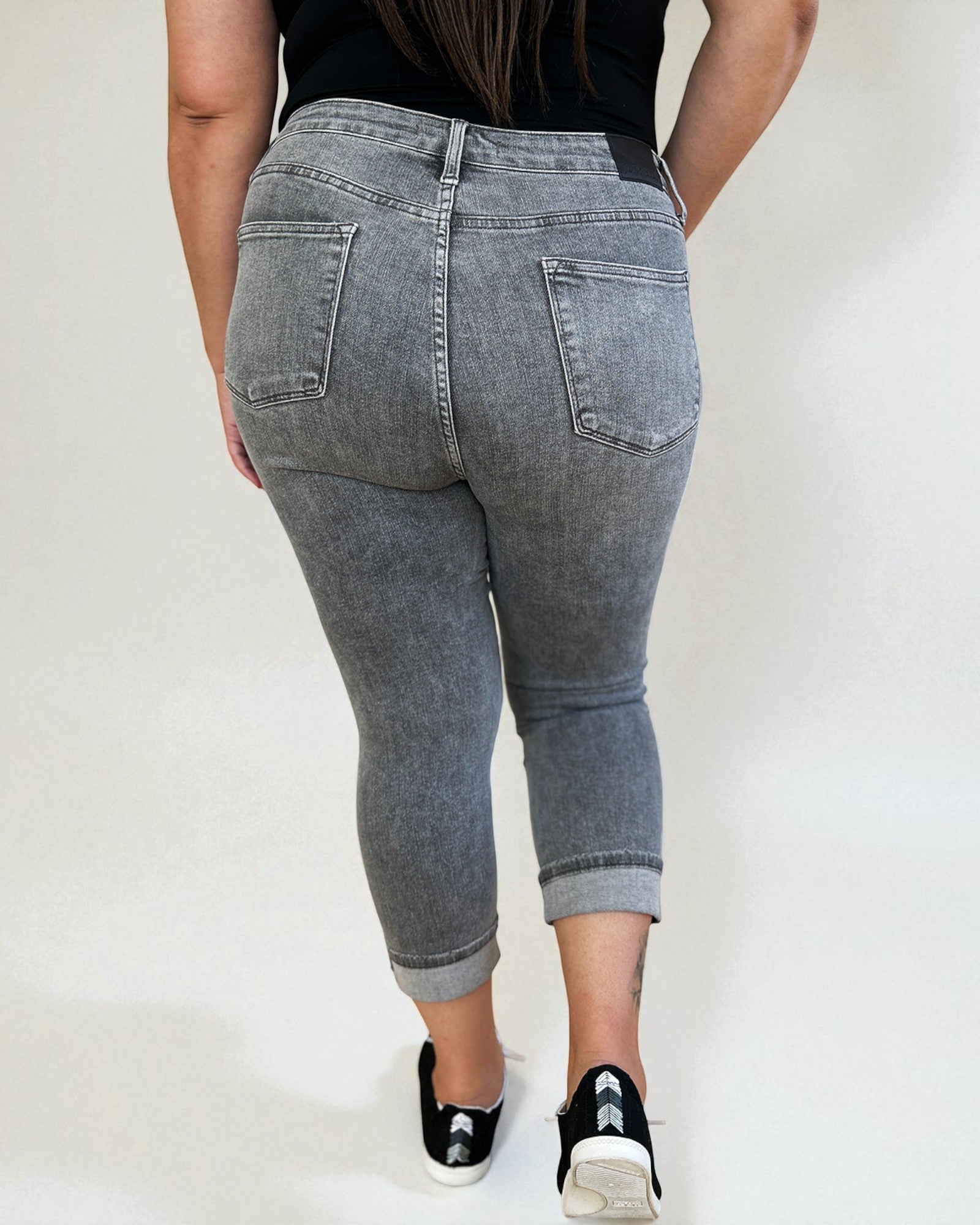 Person wearing gray jeans with a plain background