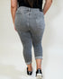 Person wearing gray jeans with a plain background