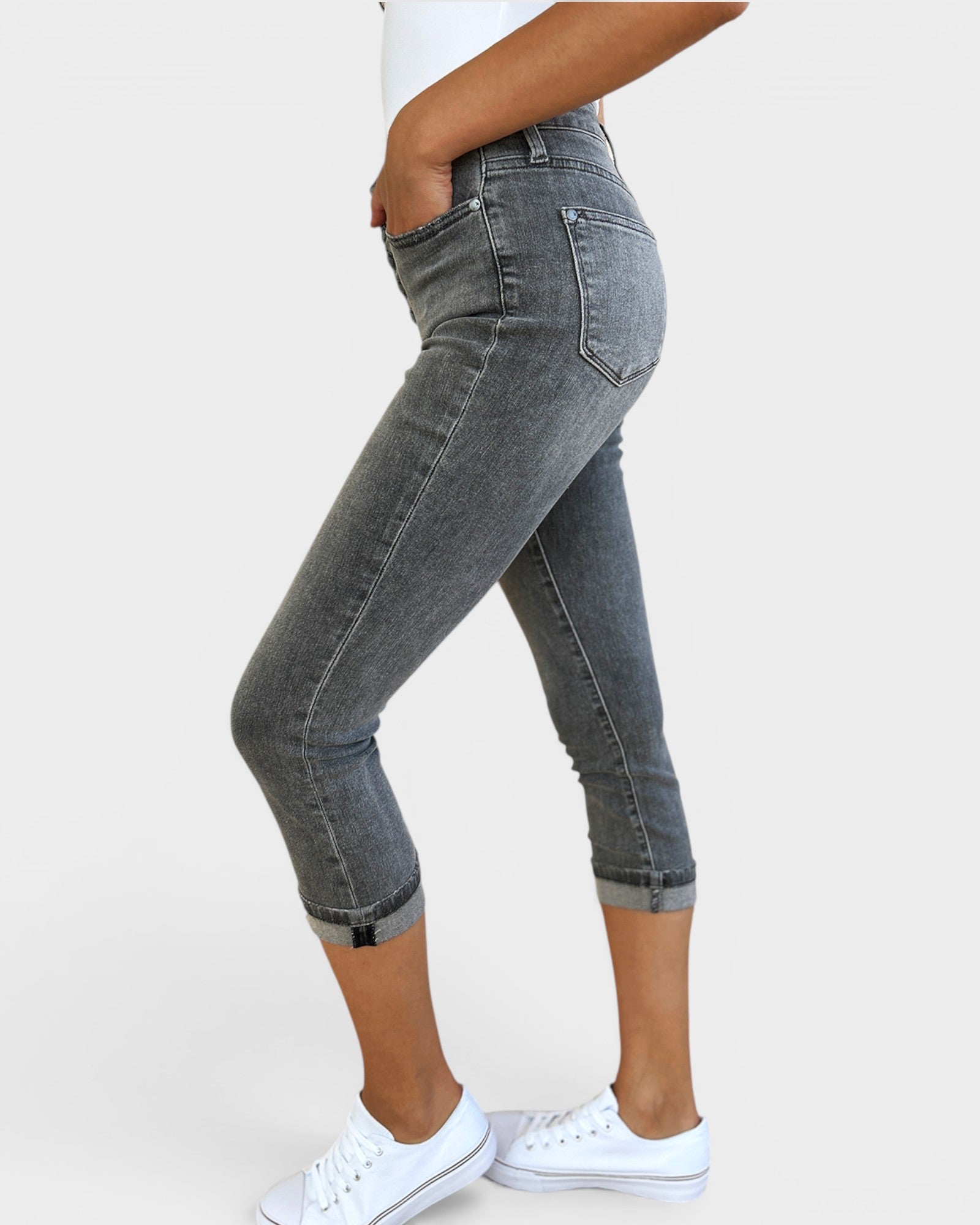Person wearing gray jeans with a white background