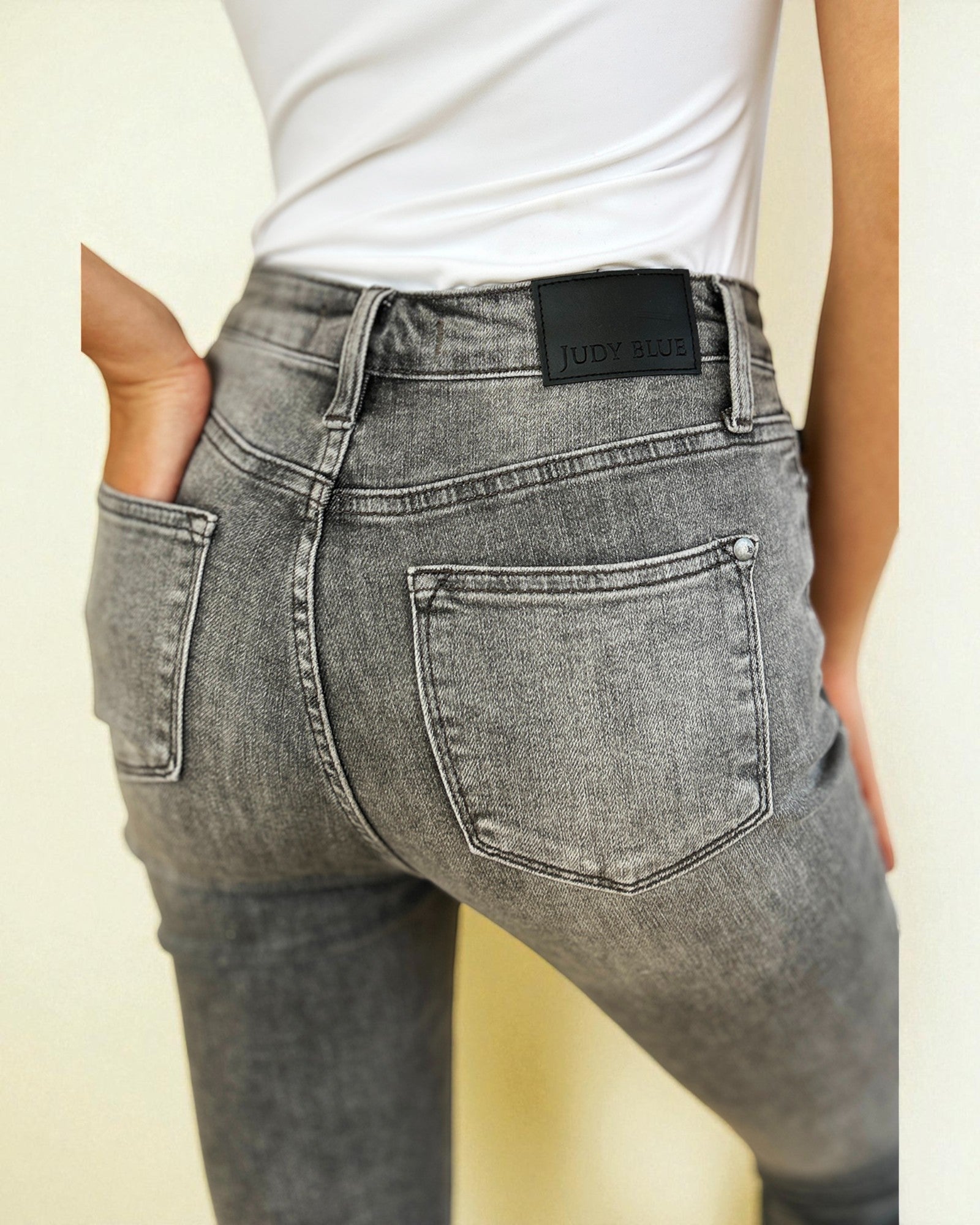Gray jeans with a brand label on a plain background