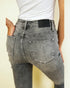 Gray jeans with a brand label on a plain background