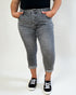 Person wearing gray jeans and black sneakers on a white background