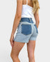 Person wearing light blue denim shorts on a plain background