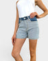 Person wearing light blue denim shorts on a white background