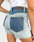 Denim shorts with a brand label on a plain background