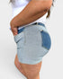 Person wearing light blue denim shorts on a plain background