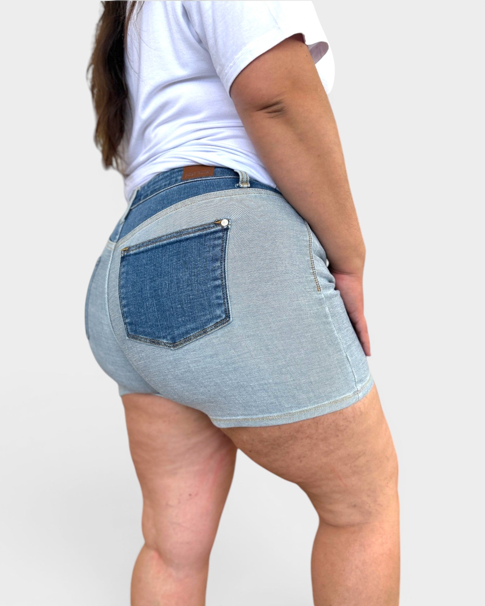 Light blue denim shorts worn by a person on a plain background