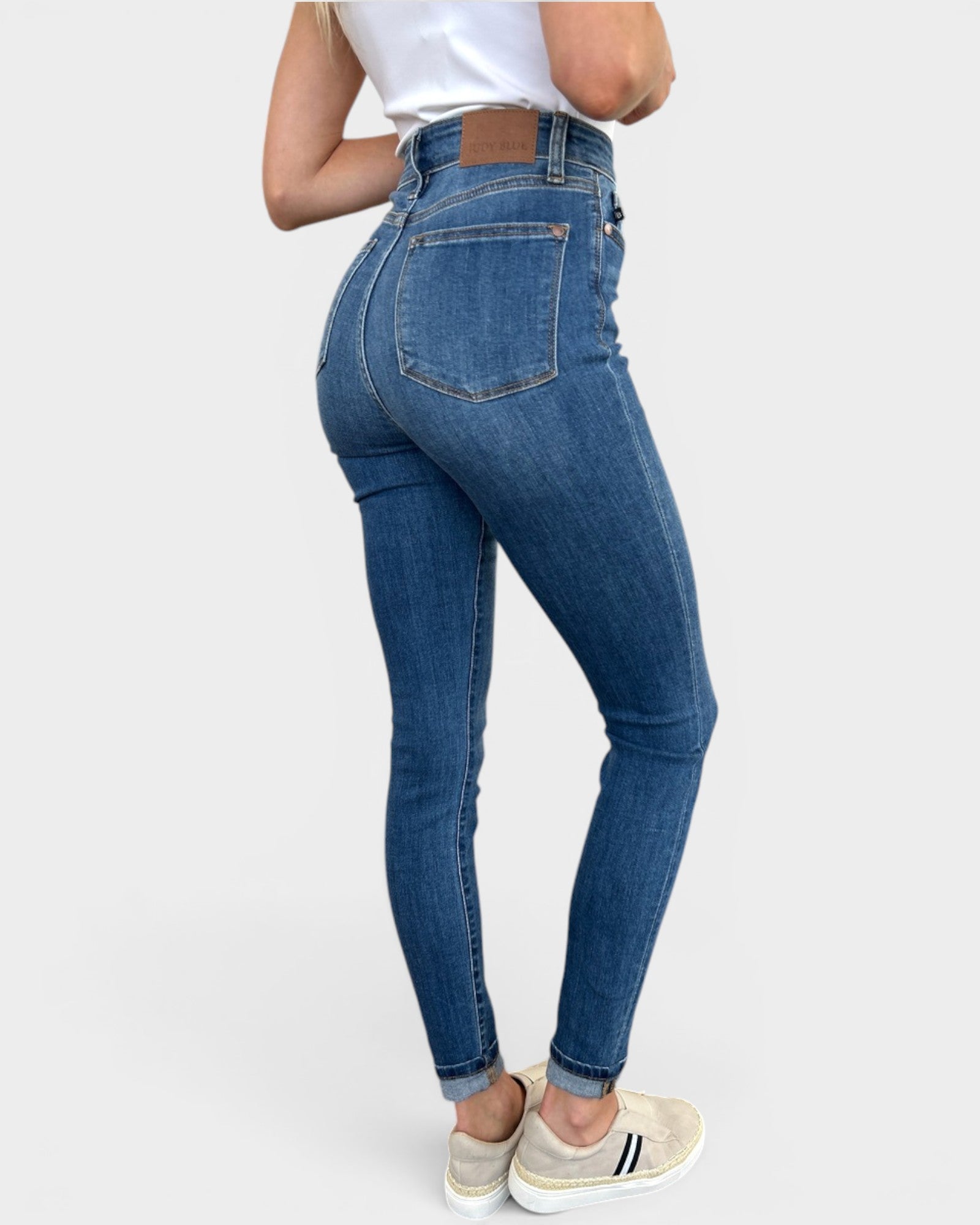 Person wearing blue jeans on a white background