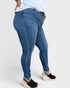 Person wearing blue jeans on a plain background