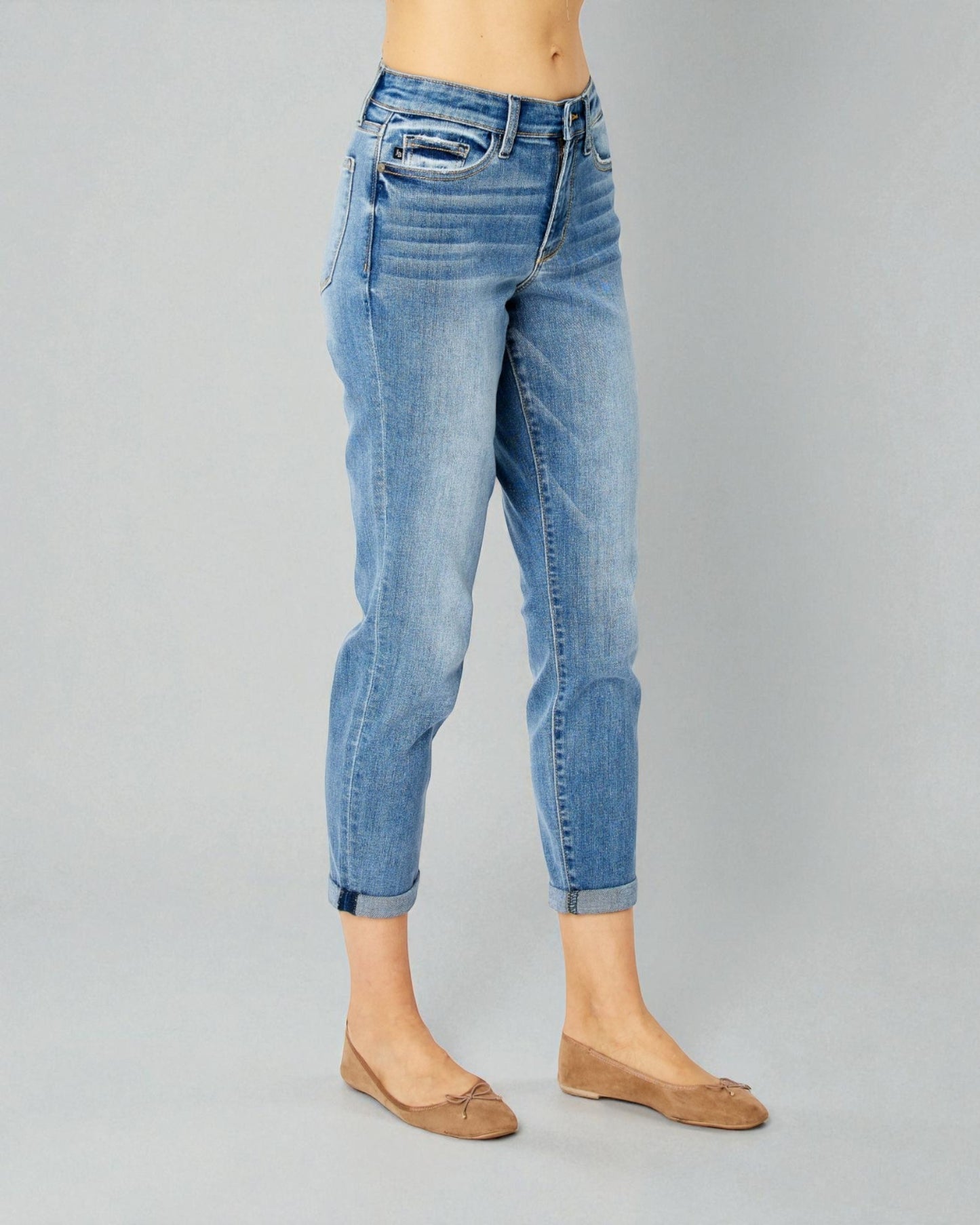 Blue jeans worn by a person on a gray background