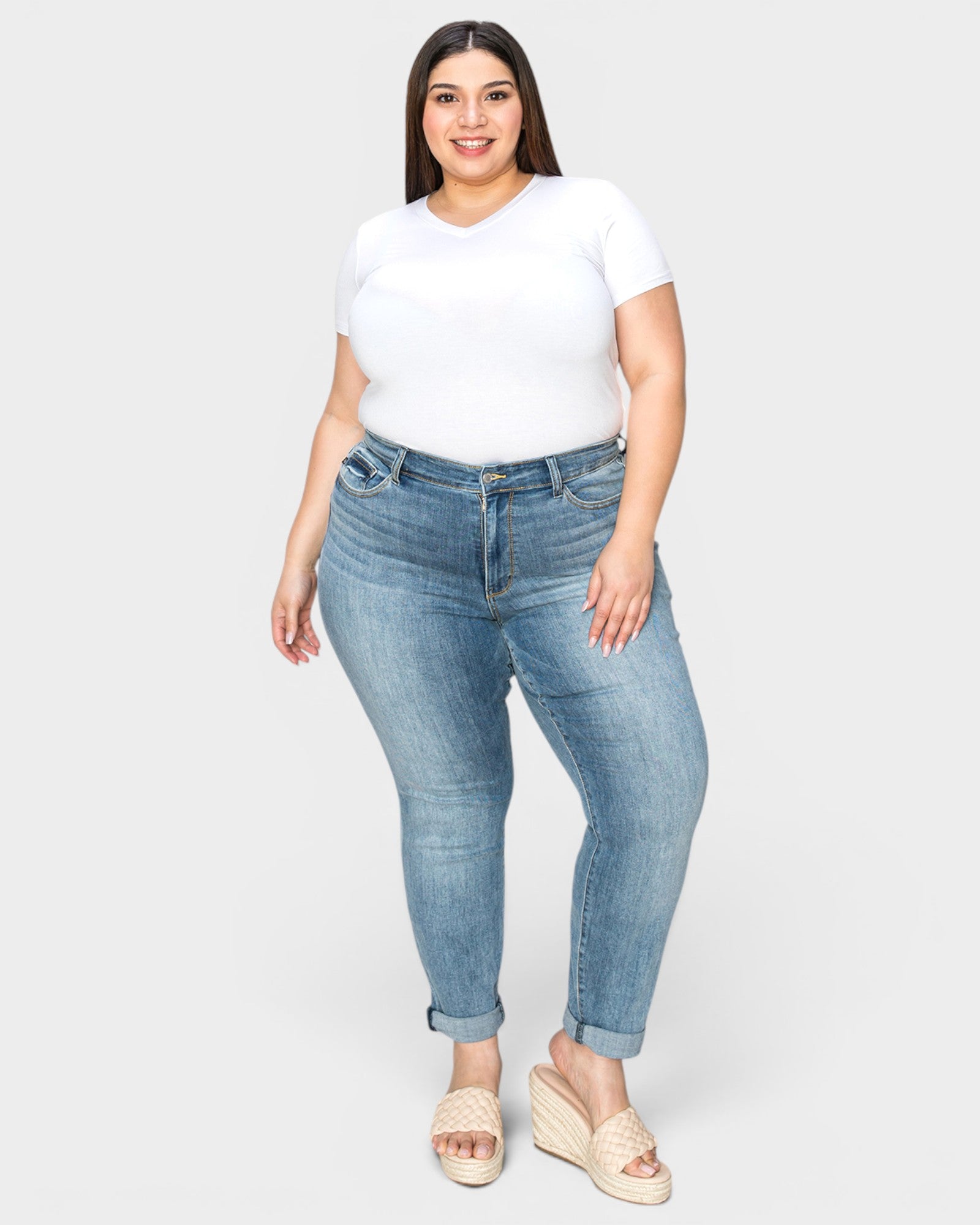 Woman wearing blue jeans and a white t-shirt on a white background