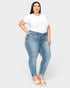 Woman wearing light blue jeans and a white t-shirt on a white background