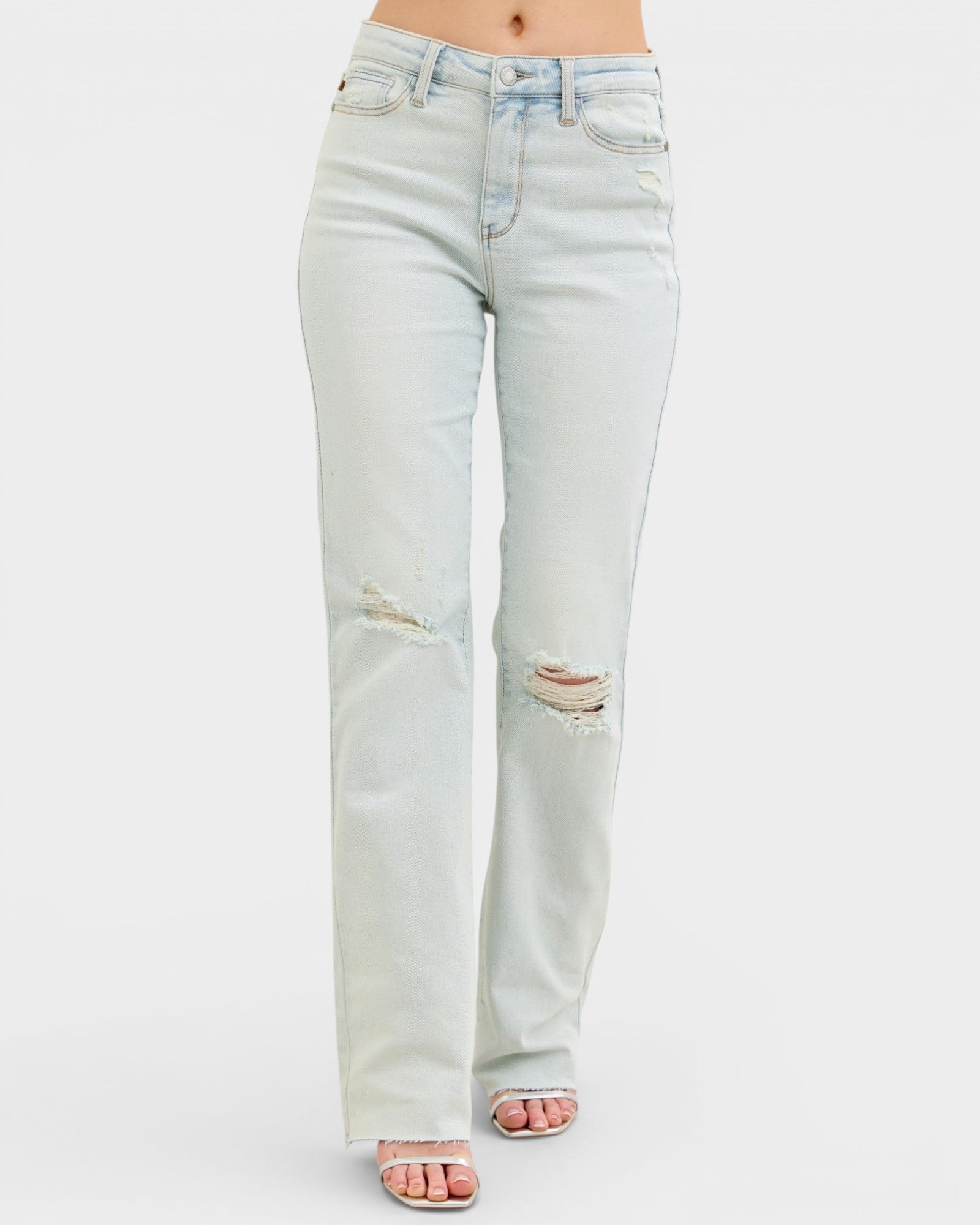Light blue jeans with slight distressing on a white background