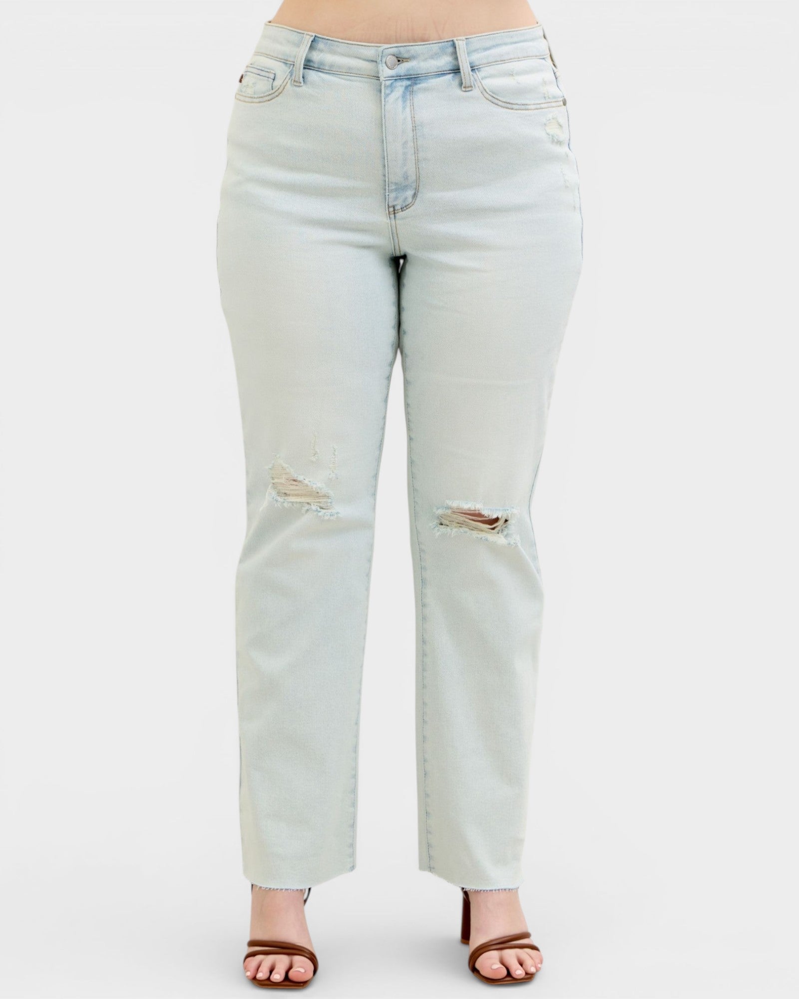 Light blue jeans with slight distressing on a white background