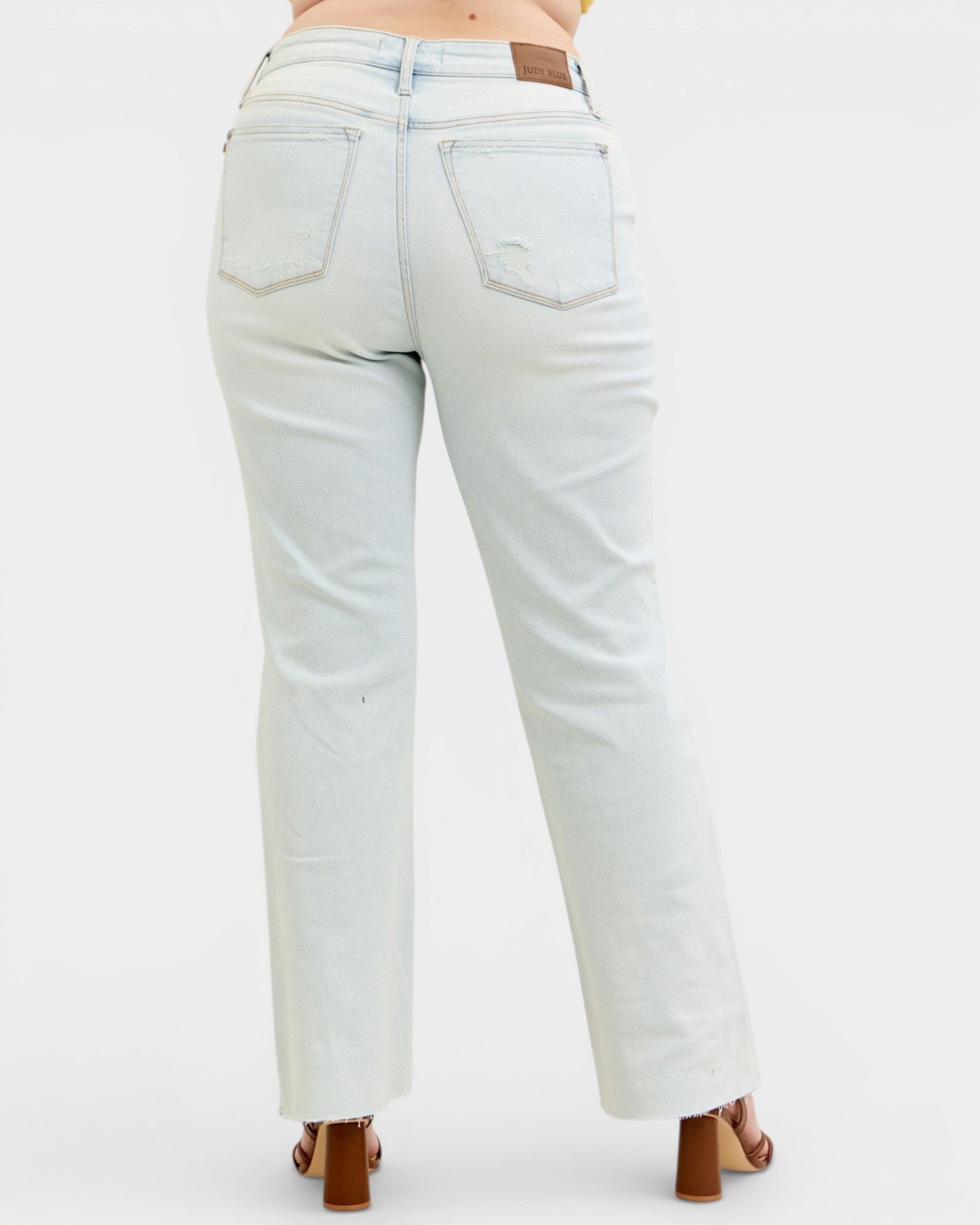 Light blue jeans worn by a person on a white background