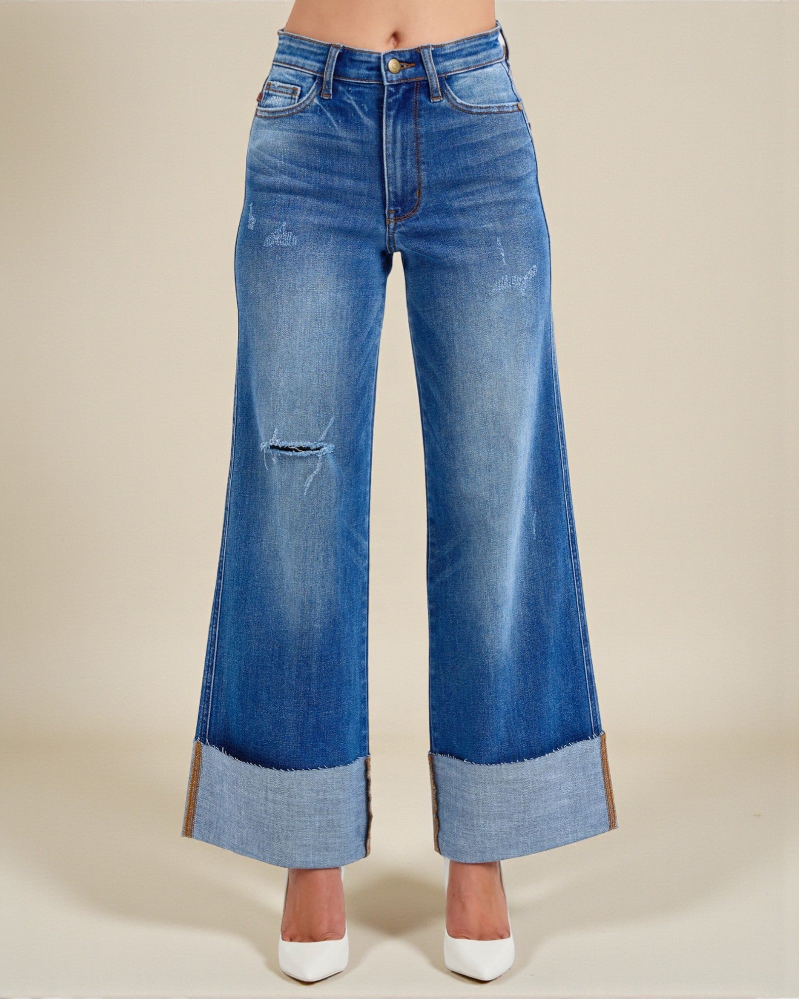 Wide-leg blue jeans on a beige background