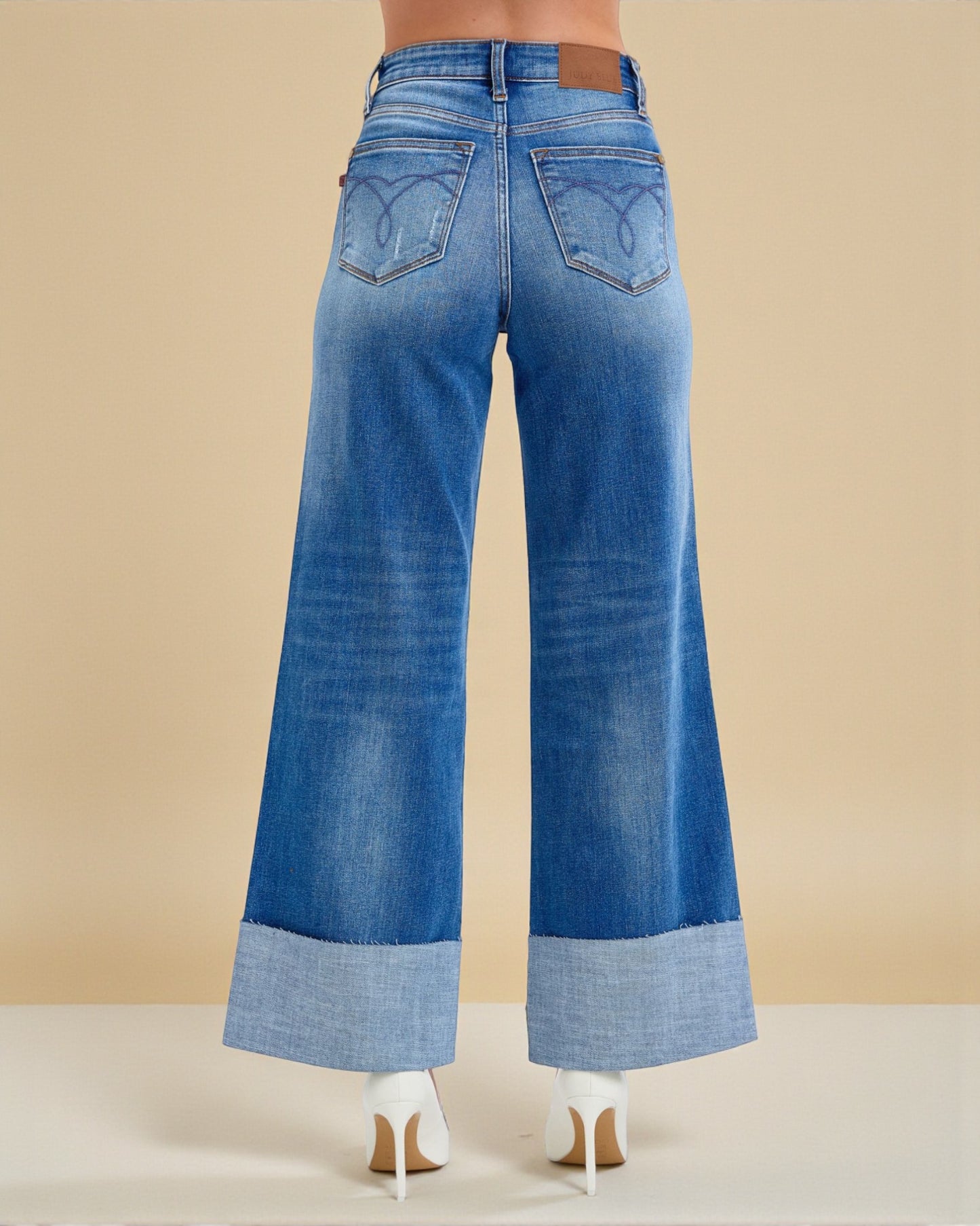 Blue wide-leg jeans on a beige background