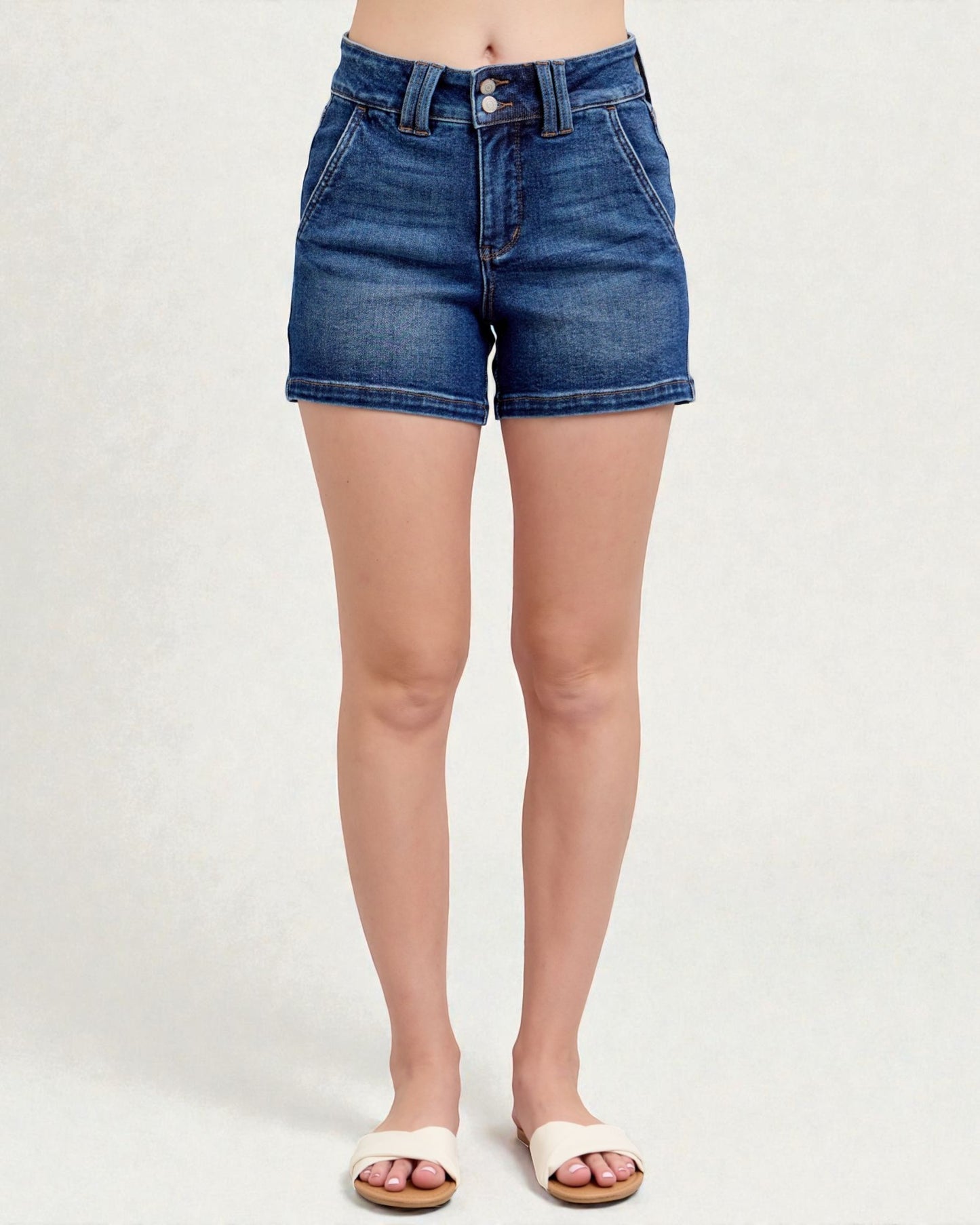 Blue denim shorts worn by a person on a white background