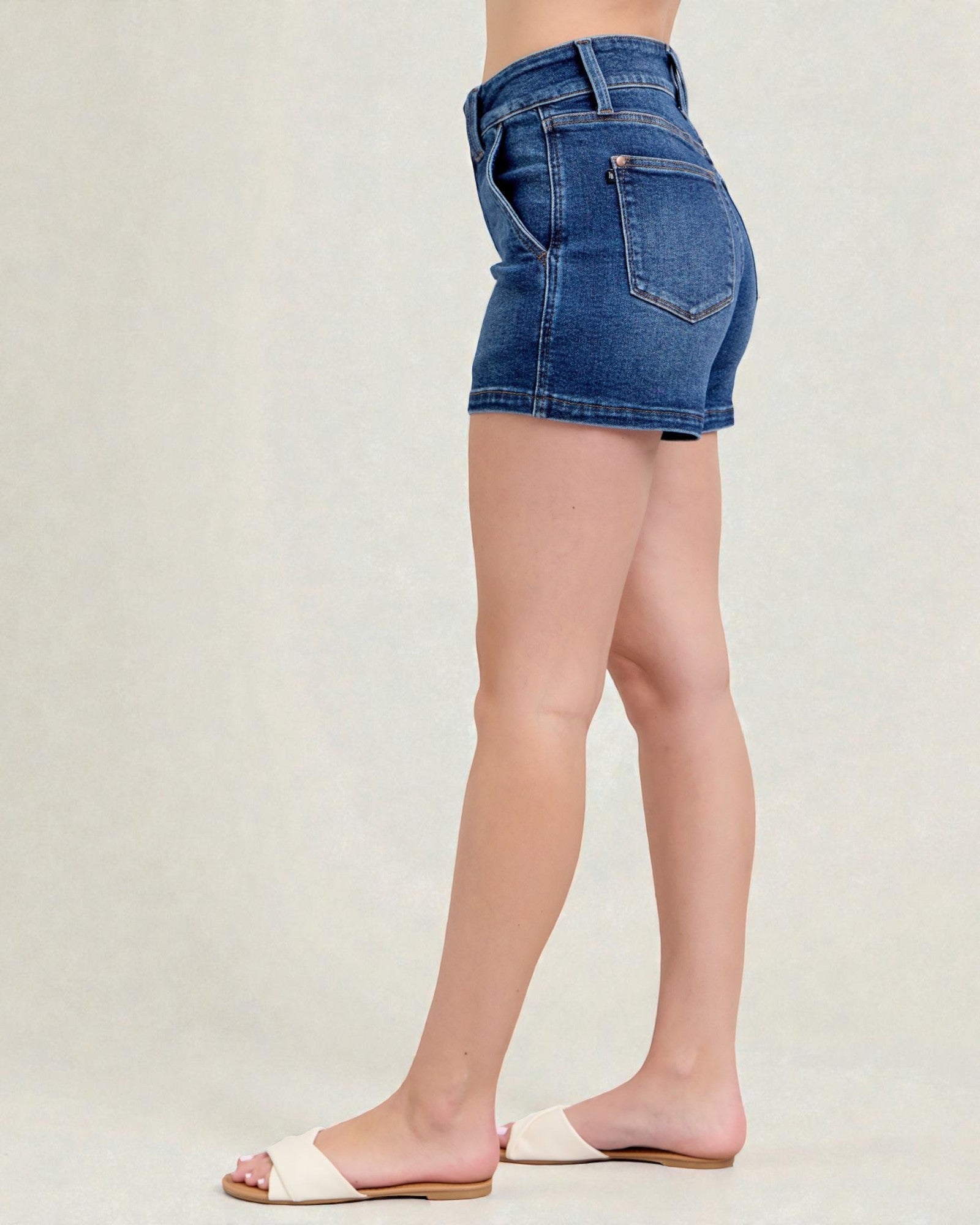 Person wearing blue denim shorts on a plain background