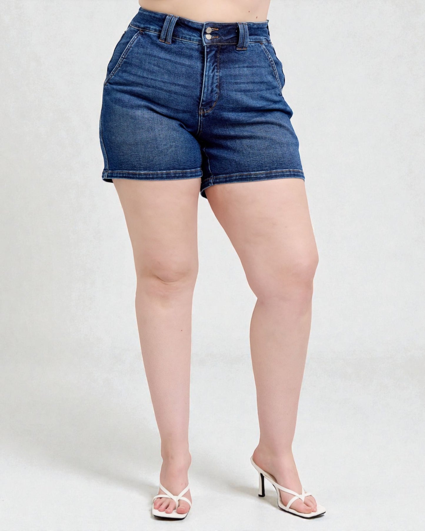 Person wearing blue denim shorts on a white background