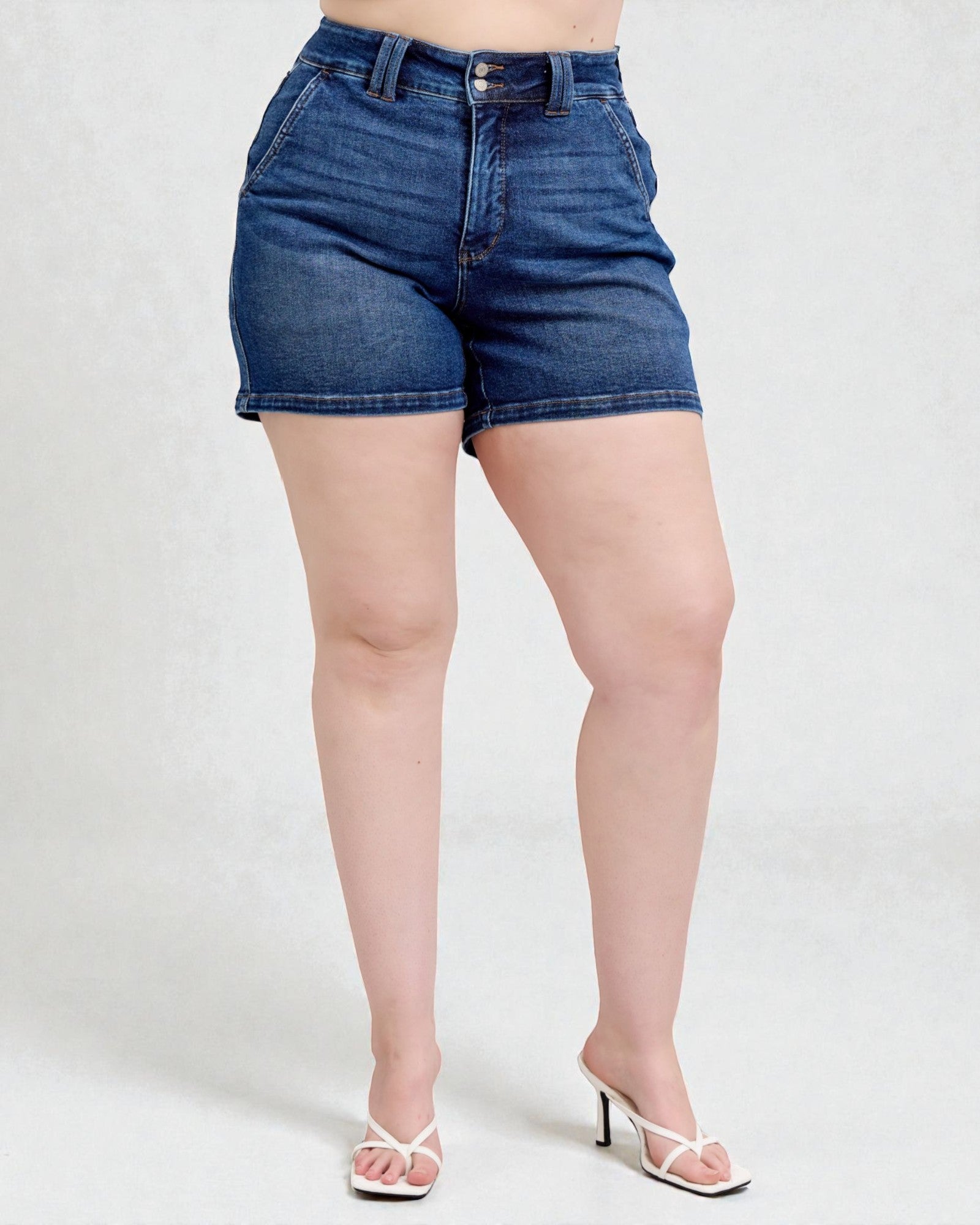 Person wearing blue denim shorts on a white background