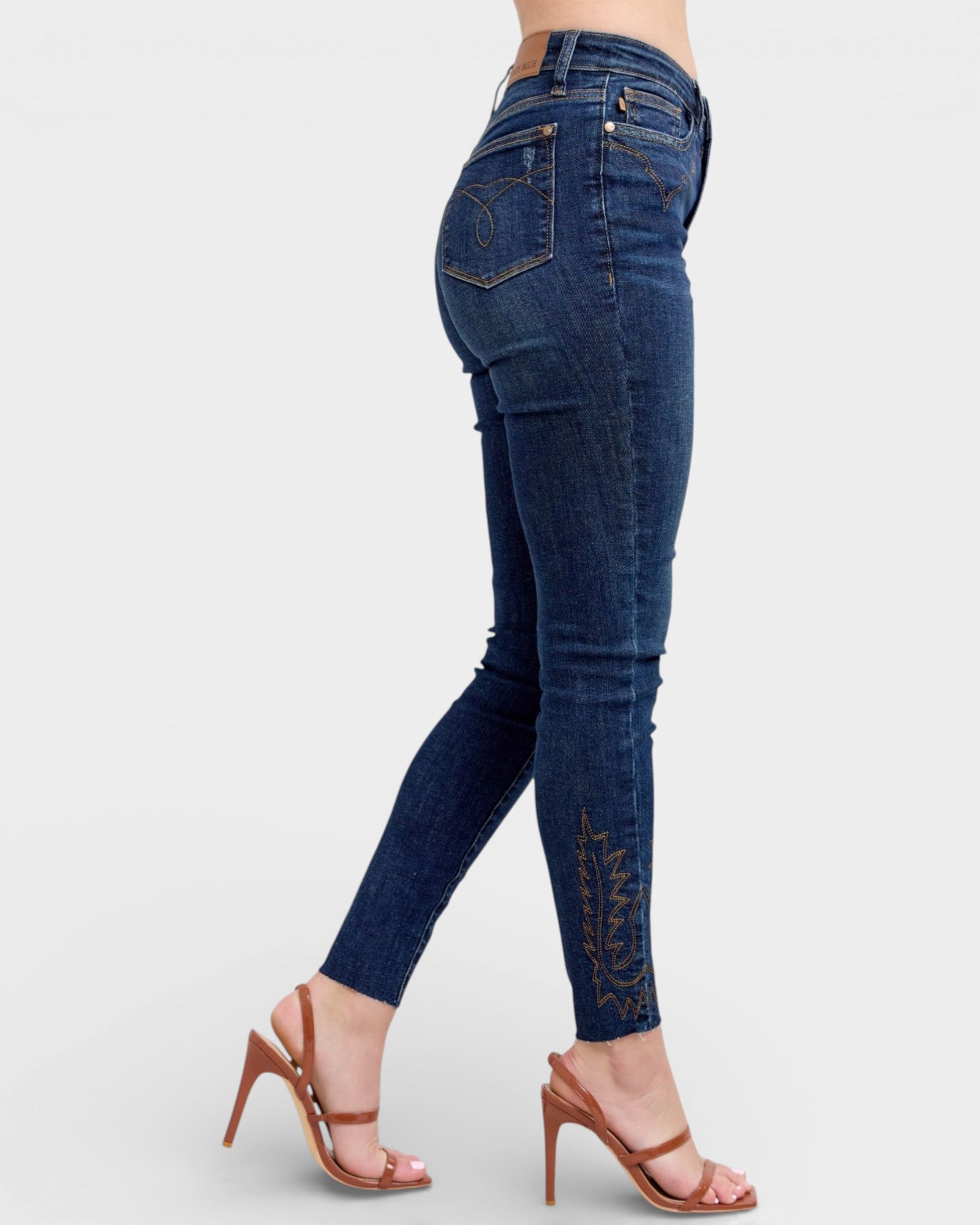 Blue jeans with decorative stitching on a white background