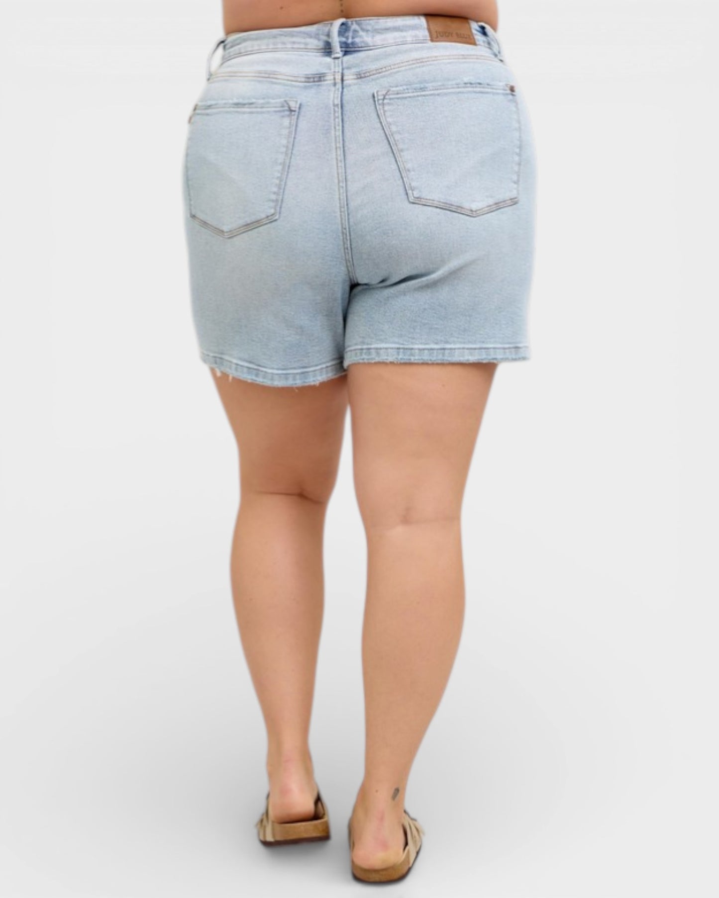 Light blue denim shorts worn by a person on a white background