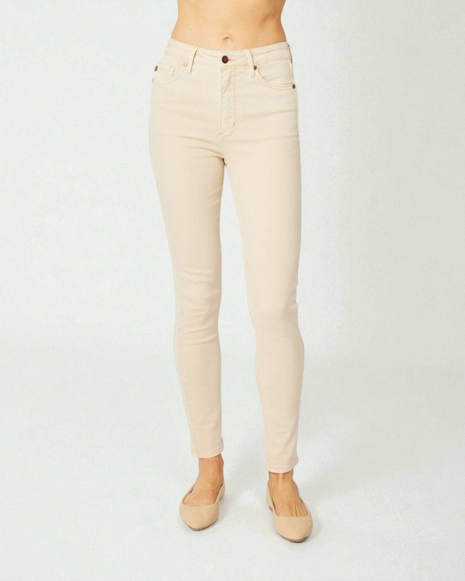 Beige jeans worn by a person on a white background